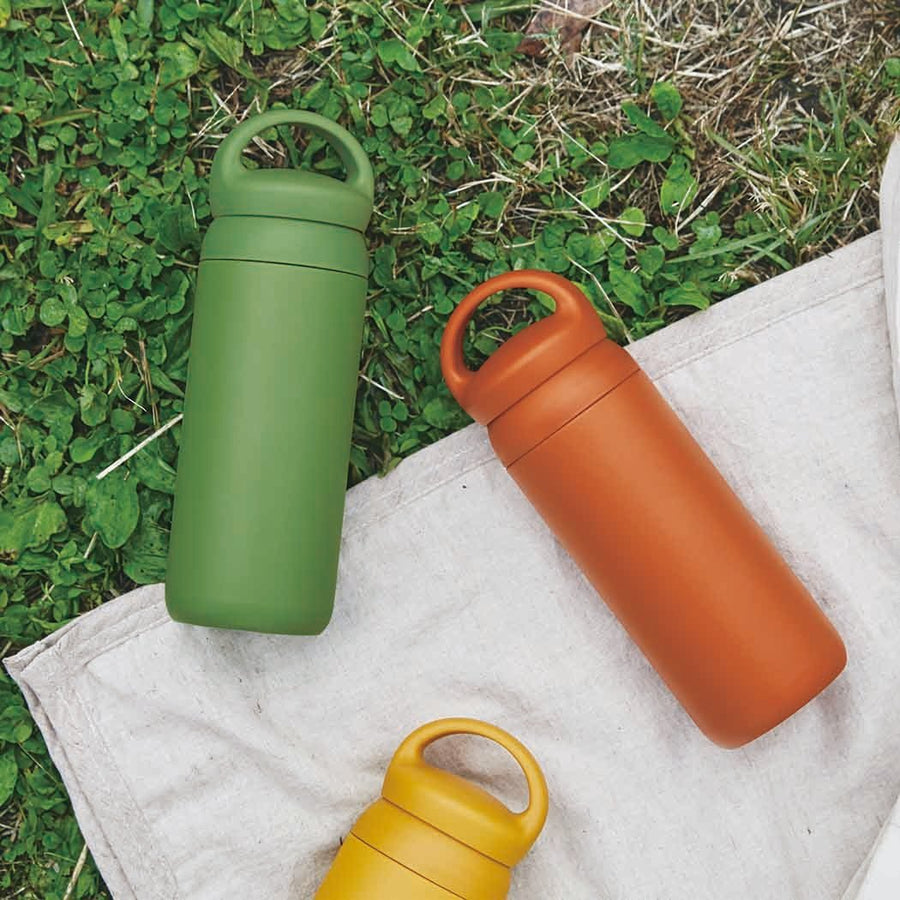 Kinto Day Off Tumbler green orange and yellow on grass